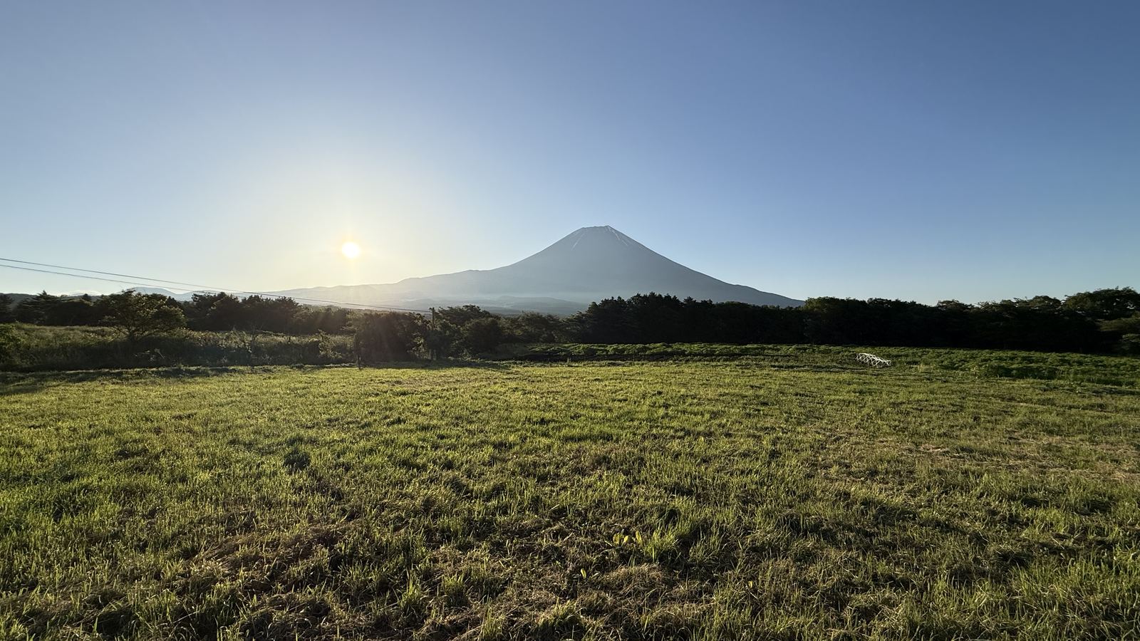 朝霧高原の農地から望む、朝日に照らされた富士山
